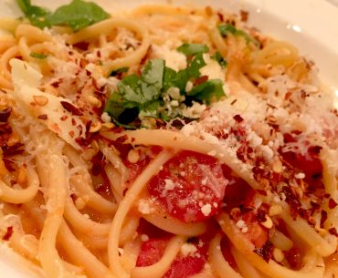 Das Bild zeigt Spaghetti mit Tomaten, Basilikum und Mozzarella.
